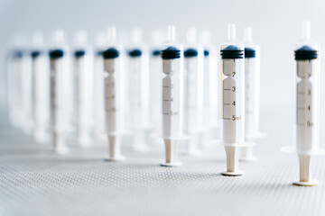 Composition of syringes with strong light coming from the right side perfectly arranged and in an aseptic place in a medical material factory and prepared for distribution