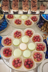 Candy bar with different assortments of cakes. Delicious sweets on wedding candy buffet with desserts, cupcakes. 