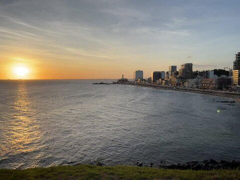 Beautiful sunset in Salvador with Barra lighthouse in the background in Brazil. Harmony between the sky and the landscape in the background painted with golden tones of the evening.