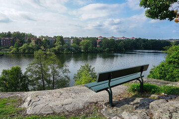 Empty park bench overlooking a river and urban landscape Stockholm Sweden