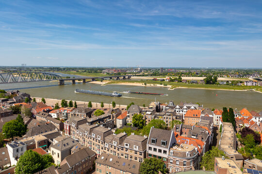 View at the Waal river with cargo riverboats passing the Dutch city of Nijmegen