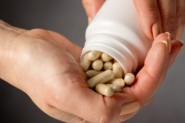 Female hands holding a heap of capsules, collagen, vitamins, pain killers, food supplements pills.