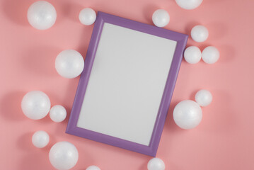 Christmas balls and picture frame on fashion background. Party mockup or invitation. Flat lay