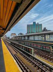 Elevated subway platform and train tracks with blue sky