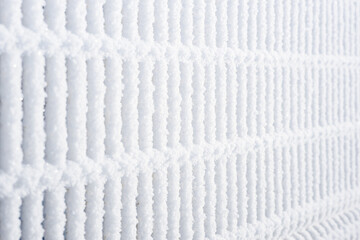 the wall is made of metal grating, the metal fence is covered with frost