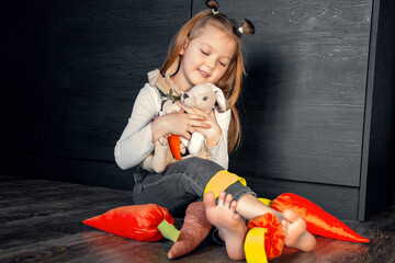A girl with toys sitting on the floor and laughing. Different emotions, positive emotions, joy, happiness, smile, child, daughter