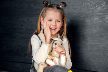 A girl with toys sitting on the floor and laughing. Different emotions, positive emotions, joy, happiness, smile, child, daughter