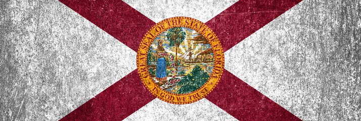Close-up of the grunge Florida State flag. Dirty Florida State flag on a metal surface.