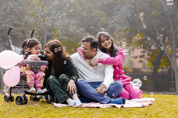 Happy Indian Latin Family Sitting together in Garden Having good time in week end