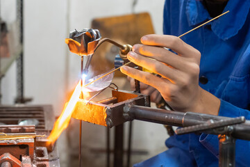 A craftsman welding a metal rose