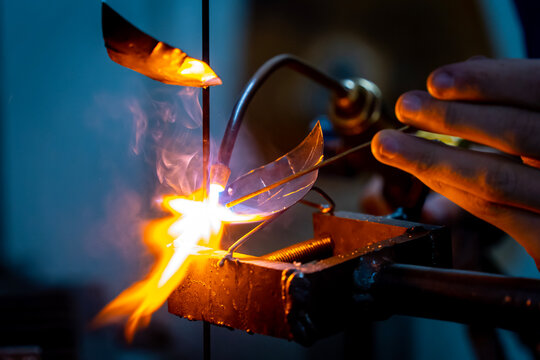 A craftsman welding a metal rose