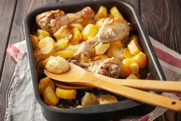 Roasted chicken legs with potatoes in  roasting pan. Comfort home food