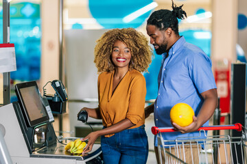 African American couple buying food at grocery store or supermarket self-checkout