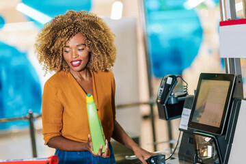 African American woman buying food at grocery store or supermarket self-checkout