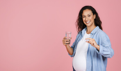 Smiling healthy young pregnant woman holding pill glass of water - obrazy, fototapety, plakaty