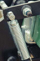 Silver spring made of steel. Part of big industrial or agricultural machine