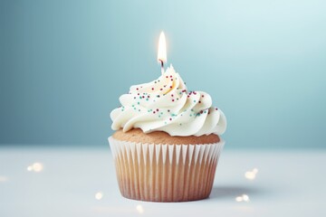 Delicious birthday cupcake with one birthday cake candle on a blue background with copy space for text