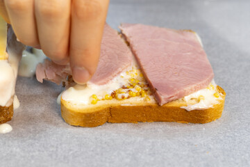 Preparing process of Croque monsieur and croque madame, grilled sandwiches with sliced ham, melted...