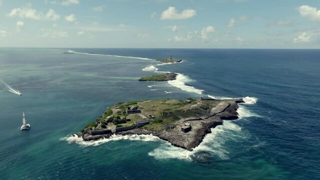Drone footage over small islands in the Indian Ocean with old ruin. Mauritius