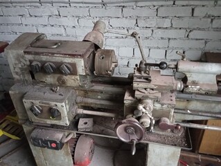 In the workshop there is a large old lathe against the background of a white brick wall. Topics of...