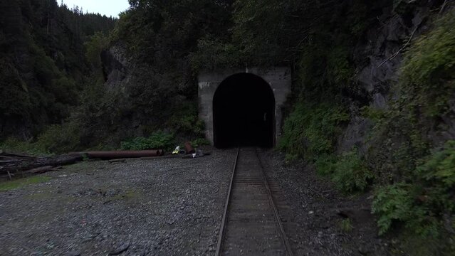 USA - 2023 - View from the front of a train as it pass through two tunnels by a mountain.