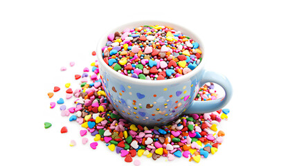  Coffee cup, full of multicolor sweet sprinkles sugar candy hearts, and packing isolated on a white background