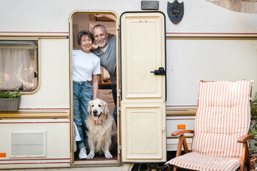 Senior old elderly family spouses husband and wife traveling together in camper van with golden...