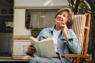 Dreamy caucasian senior old elderly woman grandmother granny reading book, relaxing, imagining...