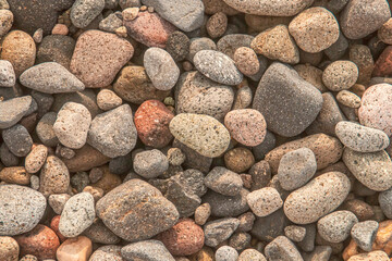 Fondo de guijarros acumulados en la playa. Composición de las coloridas gravas de las playas de Almería, Andalucía, España.