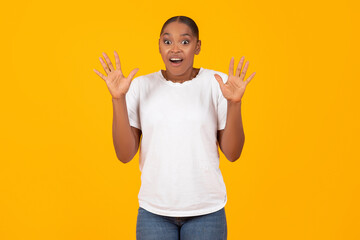 Shocked black woman got caught posing with raised hands, studio