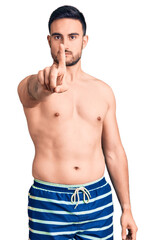 Fototapeta premium Young handsome man wearing swimwear pointing with finger up and angry expression, showing no gesture
