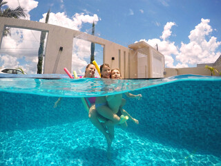 mãe brincando com filhos em água de piscina , diversão nas férias de verão 