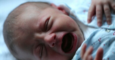 Upset newborn baby crying wanting attention