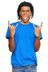 Young african american man wearing casual clothes shouting with crazy expression doing rock symbol with hands up. music star. heavy concept.