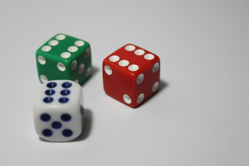 Close up of three different colored dice red, green, and white isolated on white background