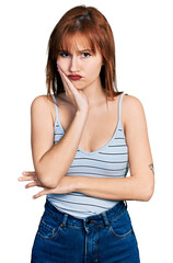 Fototapeta premium Redhead young woman wearing casual style with sleeveless shirt thinking looking tired and bored with depression problems with crossed arms.