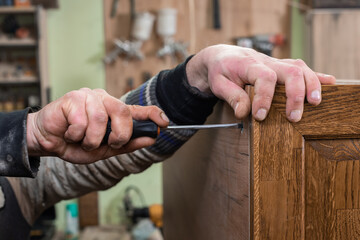 The carpenter connects the panels with a screwdriver