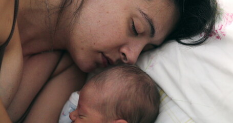 Newborn baby sleeping next to mother in bed, love and care