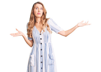 Young caucasian woman with blond hair wearing summer dress clueless and confused expression with...