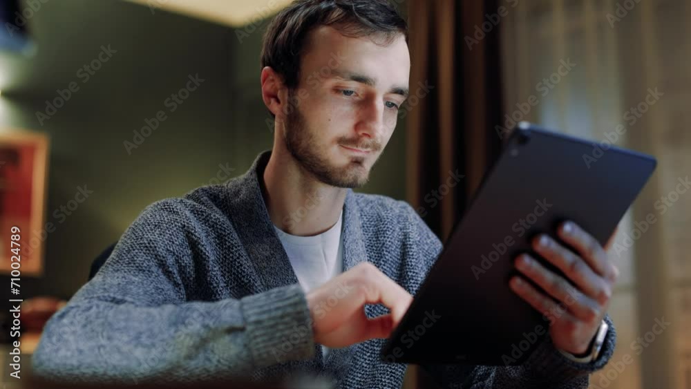 Wall mural close up view of guy using tablet. male touching screen of device. man spending time alone using tab