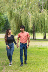 Fototapeta premium Couple in love walk holding hands in the park