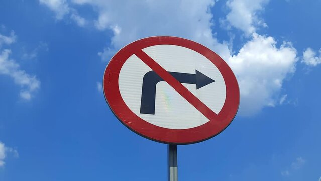 Road sign No right turn against background of blue sky with clouds. Turning is prohibited. Concept of ban, forbidden, restriction of freedom, choice of path, new life. Wrong turn.