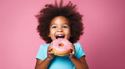 Plexiglas foto achterwand cute child excited about eating a big donut on the blue background, pink © IgnacioJulian
