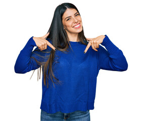 Young hispanic woman wearing casual clothes looking confident with smile on face, pointing oneself...