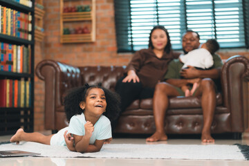 Family enjoy spend wellbeing time together, African father and Asian Mother having a playful time with their kid, carefree and comfort time at sofa in the living room, togetherness in family or parent
