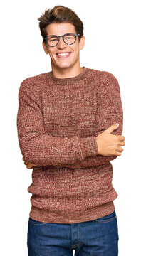 Handsome caucasian man wearing casual sweater and glasses looking positive and happy standing and smiling with a confident smile showing teeth