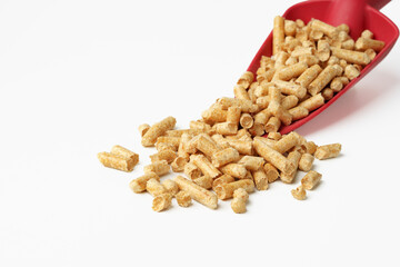 Red scoop with wood pellets isolated on white