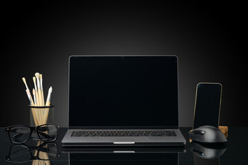 Fototapeta na wymiar Working table with laptop on black background