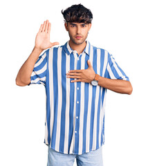 Young hispanic man wearing casual clothes swearing with hand on chest and open palm, making a...
