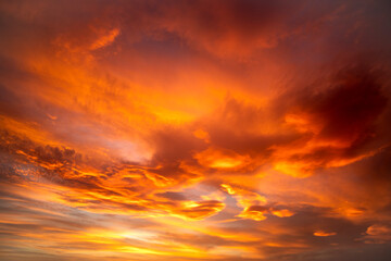 Dramatic sky with high clouds at sunset with different orange, yellow and pink colors perfect for...